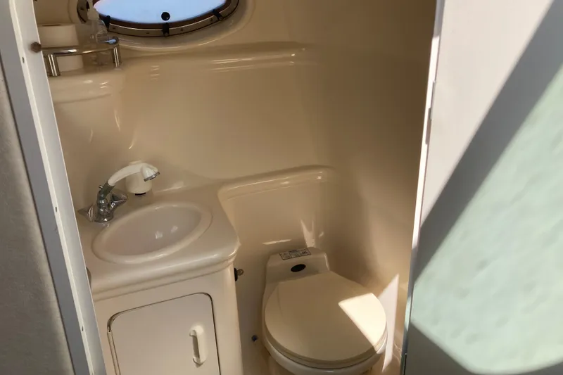 Slide: The Image of Compact bathroom in 2002 Sea Ray Sundancer 260 boat, featuring sink and toilet. - 38