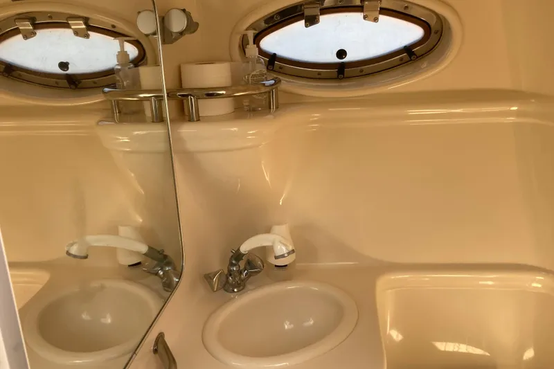Slide: The Image of Bathroom interior of 2002 Sea Ray Sundancer 260 with sink and porthole windows. - 39