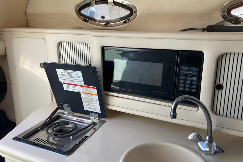 Slide: The Image of 2002 Sea Ray Sundancer 260 interior kitchen with stove, microwave, and sink. - 40