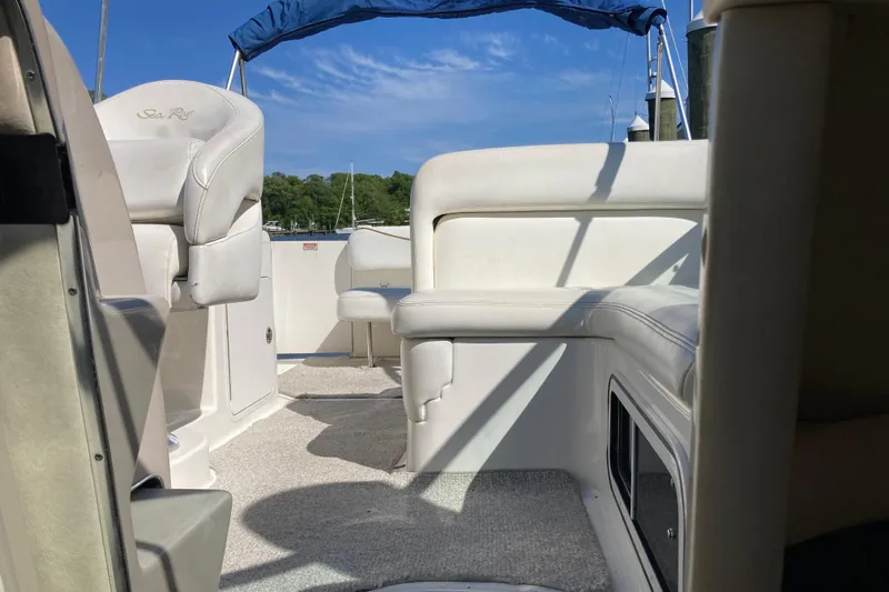 Slide: The Image of Interior view of a 2002 Sea Ray Sundancer 260 boat with white seating and blue canopy. - 47