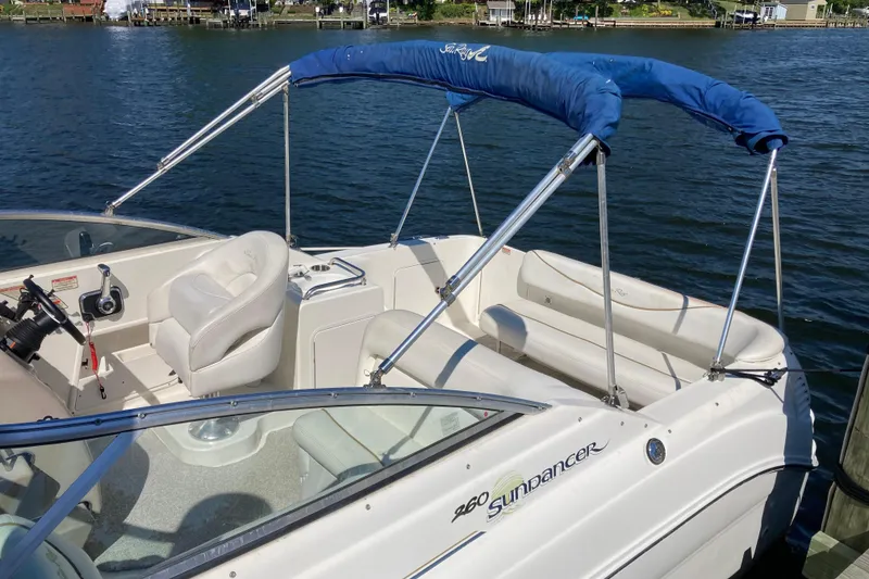 Slide: The Image of 2002 Sea Ray Sundancer 260 boat with blue canopy on a calm lake. - 8