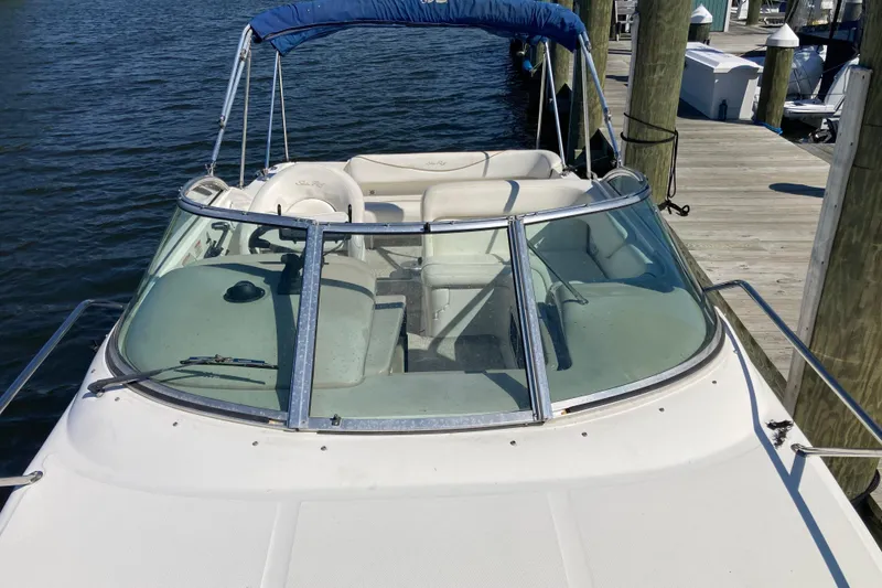 Slide: The Image of 2002 Sea Ray Sundancer 260 boat docked at marina, featuring spacious seating and windshield. - 9