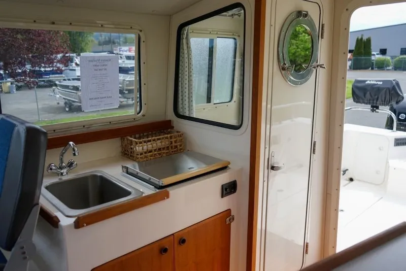 Slide: The Image of Interior of 2018 C-Dory 25' Tomcat Catamaran with sink and window view. - 10