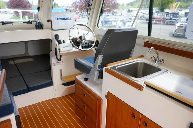 Slide: The Image of Interior of 2018 C-Dory 25' Tomcat Catamaran with helm, sink, and seating area. - 15