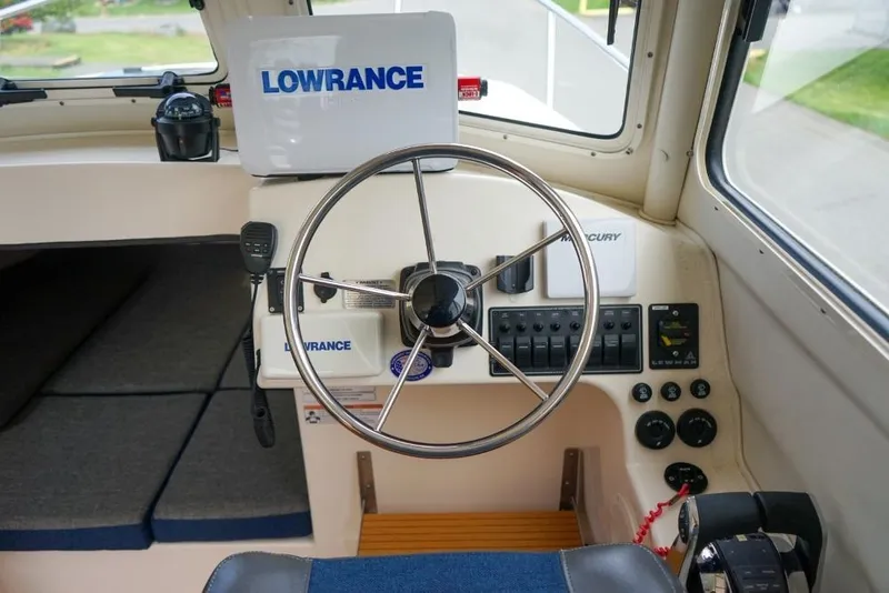 Slide: The Image of 2018 C-Dory 25' Tomcat Catamaran helm with Lowrance navigation system and steering wheel. - 16