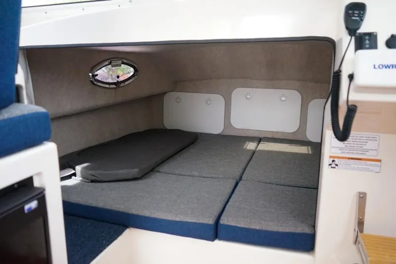Slide: The Image of 2018 C-Dory 25' Tomcat Catamaran interior cabin with cushioned sleeping area. - 20
