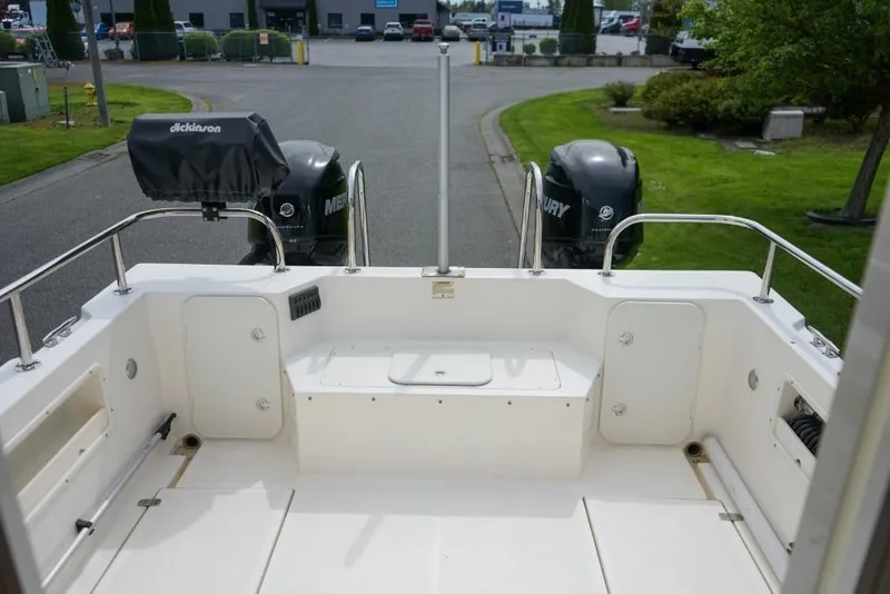 Slide: The Image of 2018 C-Dory 25' Tomcat Catamaran with dual Mercury engines, docked in a marina. - 23