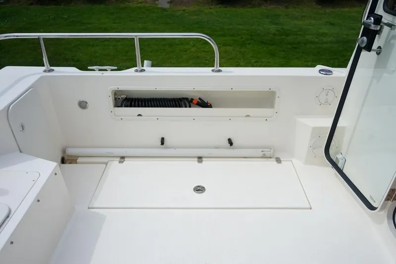 Slide: The Image of 2018 C-Dory 25' Tomcat Catamaran deck with storage compartment and railing. - 25