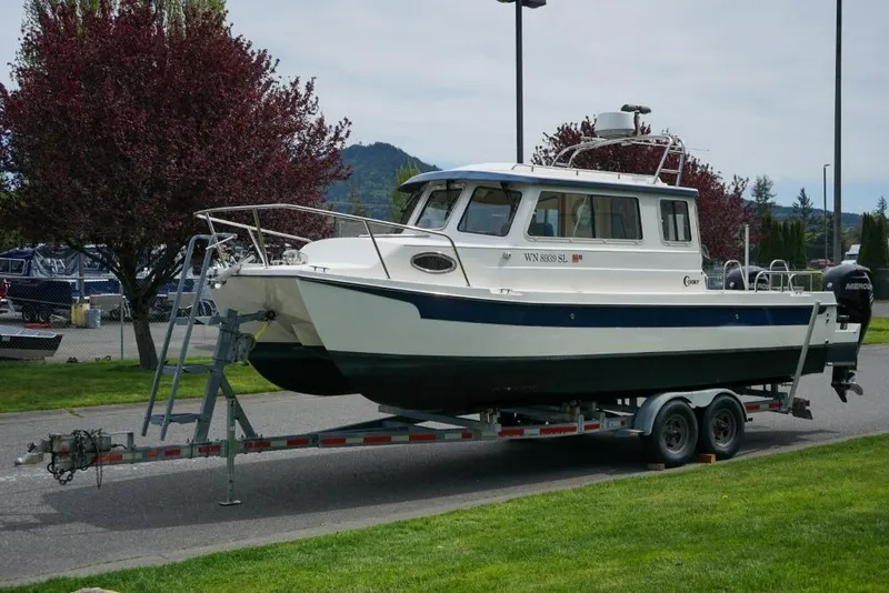 Slide: The Image of 2018 C-Dory 25' Tomcat Catamaran on trailer, parked outdoors. - 3