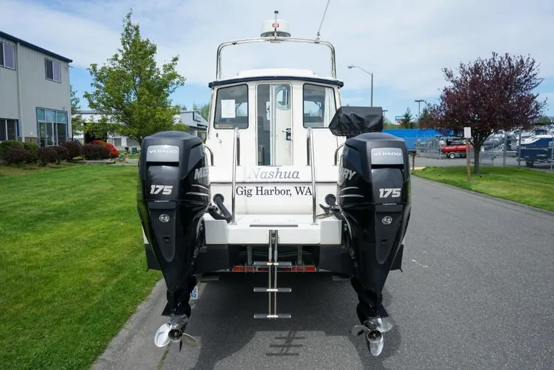 Slide: The Image of 2018 C-Dory 25' Tomcat Catamaran with dual Mercury 175 engines, parked outdoors. - 5
