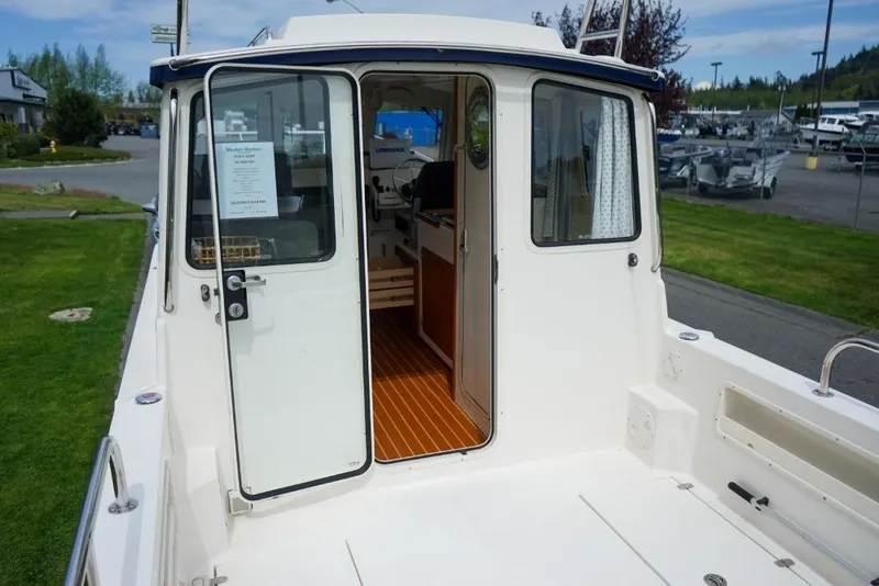 Slide: The Image of 2018 C-Dory 25' Tomcat Catamaran with open cabin door, docked outdoors. - 6