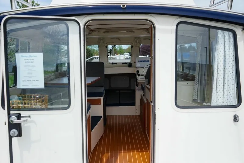 Slide: The Image of 2018 C-Dory 25' Tomcat Catamaran interior view with wood flooring and seating. - 8