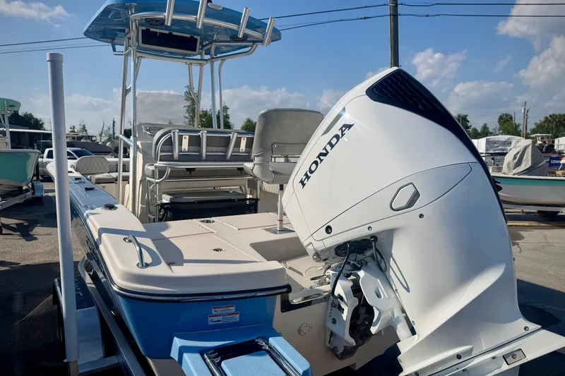 Slide: The Image of 2026 Carolina Skiff 22 Ultra Elite boat with Honda outboard motor, docked under clear skies. - 39