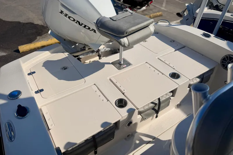 Slide: The Image of 2026 Carolina Skiff 22 Ultra Elite boat deck with Honda motor, featuring storage compartments. - 5
