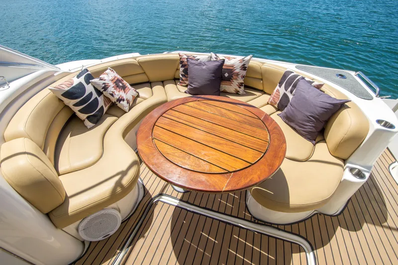 Slide: The Image of Luxurious seating area on 2005 Cruisers Yachts 540 Express with cushions and wooden table. - 10