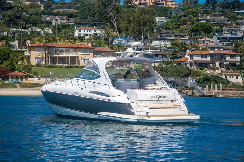 Slide: The Image of Luxury 2005 Cruisers Yachts 540 Express on serene water with scenic coastal backdrop. - 2