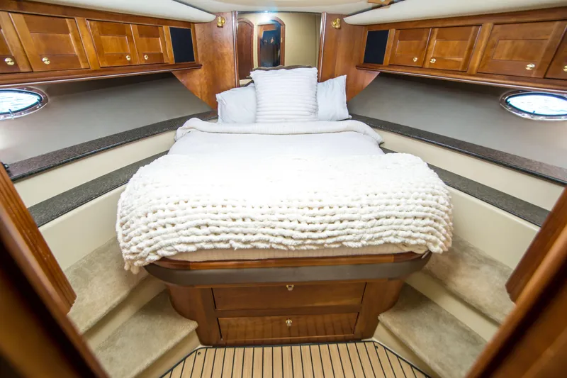 Slide: The Image of Luxurious cabin interior of 2005 Cruisers Yachts 540 Express with cozy bed and wooden cabinetry. - 26