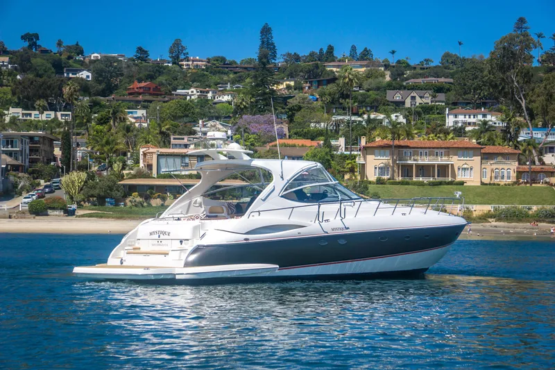 Slide: The Image of 2005 Cruisers Yachts 540 Express on water near scenic coastal homes. - 4