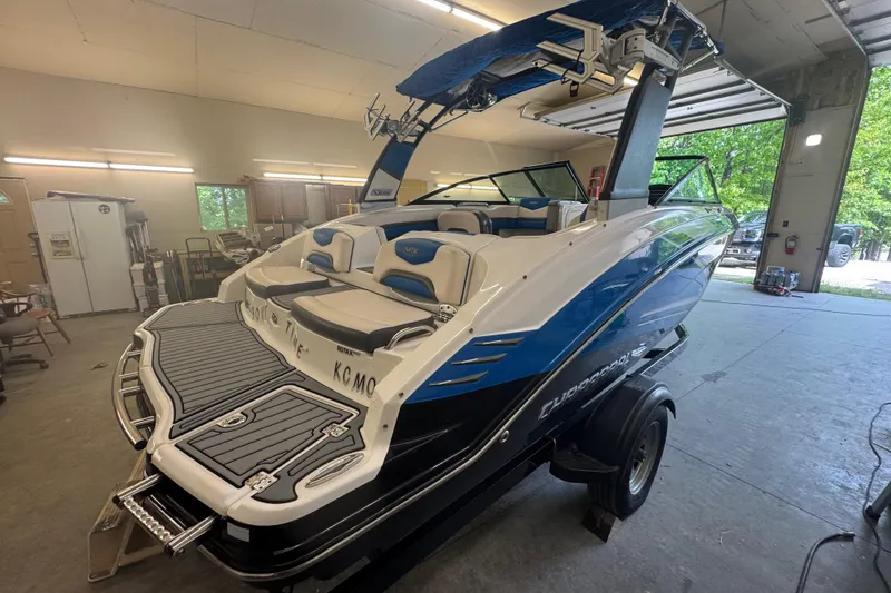 Slide: The Image of 2017 Chaparral Vortex 203 VRX boat in garage, featuring sleek design and blue accents. - 13