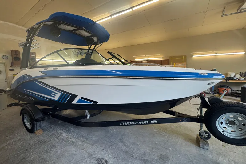 Slide: The Image of 2017 Chaparral Vortex 203 VRX boat in a garage, featuring blue and white design. - 3