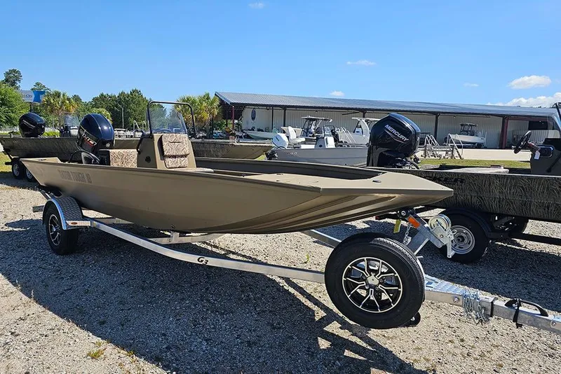 Slide: The Image of 2026 G3 Gator Tough 18 CC boat on trailer, parked outdoors under clear sky. - 20