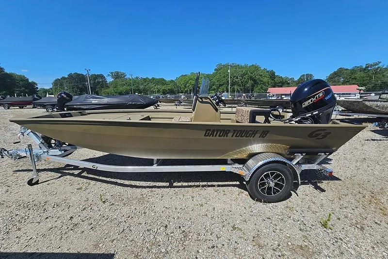 Slide: The Image of 2026 G3 Gator Tough 18 CC boat on trailer, parked outdoors under clear blue sky. - 25