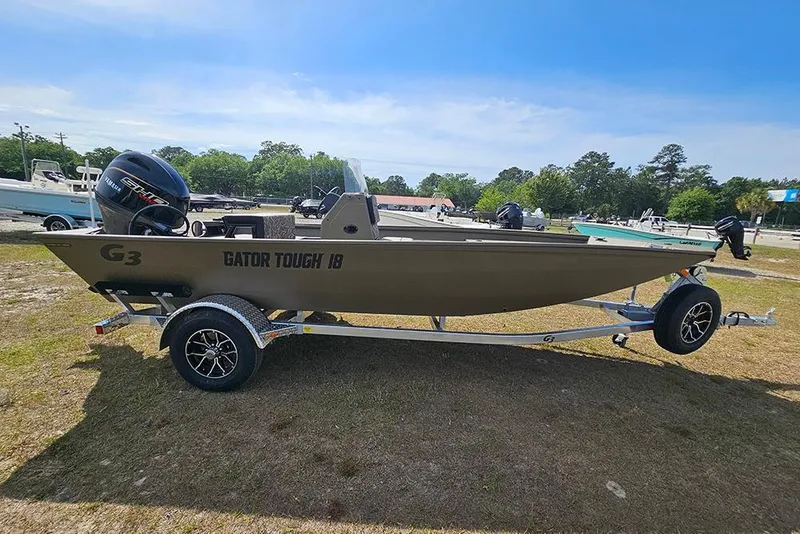 Slide: The Image of 2026 G3 Gator Tough 18 CC boat on trailer, parked outdoors under clear sky. - 7