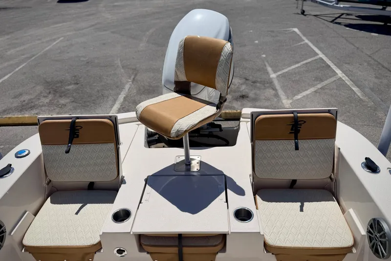 Slide: The Image of 2026 Carolina Skiff 24 Ultra Elite boat seating and helm, featuring tan and white upholstery. - 2