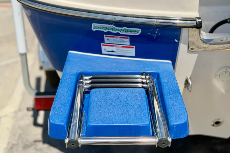 Slide: The Image of 2026 Carolina Skiff 24 Ultra Elite boat with blue swim platform and ladder. - 27