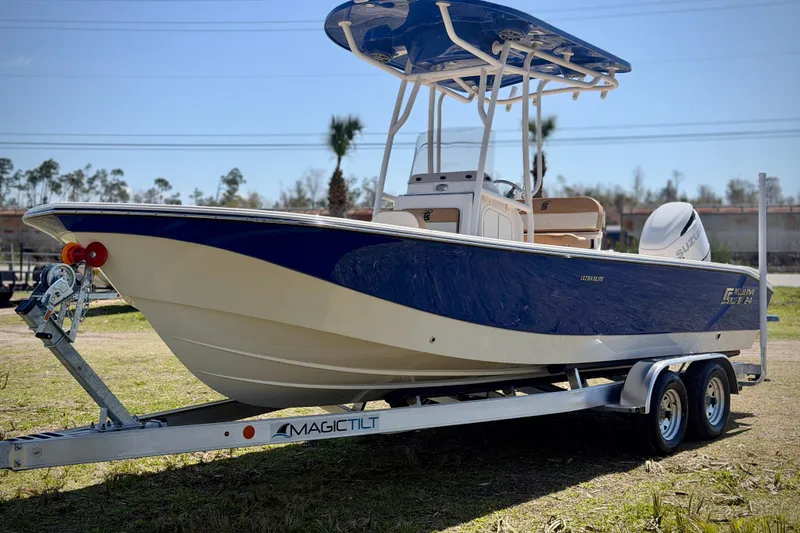 Slide: The Image of 2026 Carolina Skiff 24 Ultra Elite boat on trailer, blue and white design. - 31
