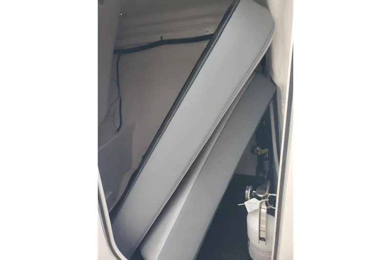 Slide: The Image of Storage compartment in 2026 Chaparral 23 SSi boat with cushions and fire extinguisher. - 12