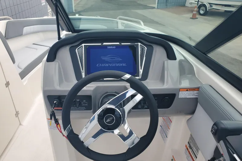 Slide: The Image of 2026 Chaparral 23 SSi boat dashboard with steering wheel and digital display. - 2