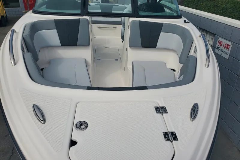 Slide: The Image of 2026 Chaparral 23 SSi boat interior with gray and white seating, docked near a fire lane. - 7
