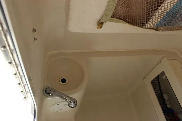Slide: The Image of Interior of a 2015 Sailfish 240 CC featuring sink and storage area. - 39