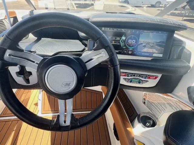 Slide: The Image of Interior view of 2017 Nautique G25 boat cockpit with steering wheel and display. - 18