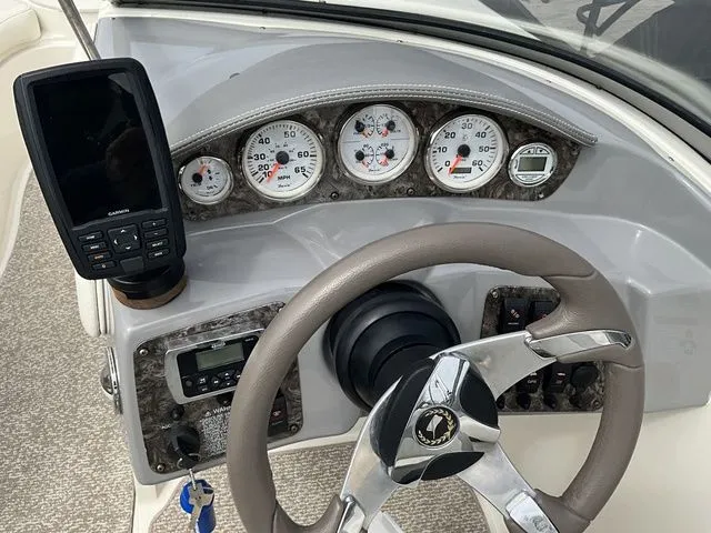 Slide: The Image of Dashboard of a 2013 Stingray 208 LR boat with instruments and steering wheel. - 27