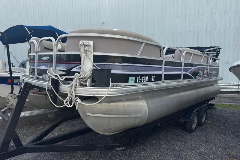 The Image of 2015 Sun Tracker Party Barge 22 DLX pontoon boat on trailer, parked outdoors. - 1
