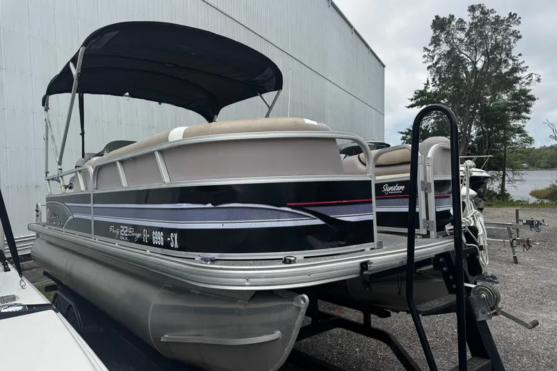 Slide: The Image of 2015 Sun Tracker Party Barge 22 DLX pontoon boat on trailer near a lake. - 11