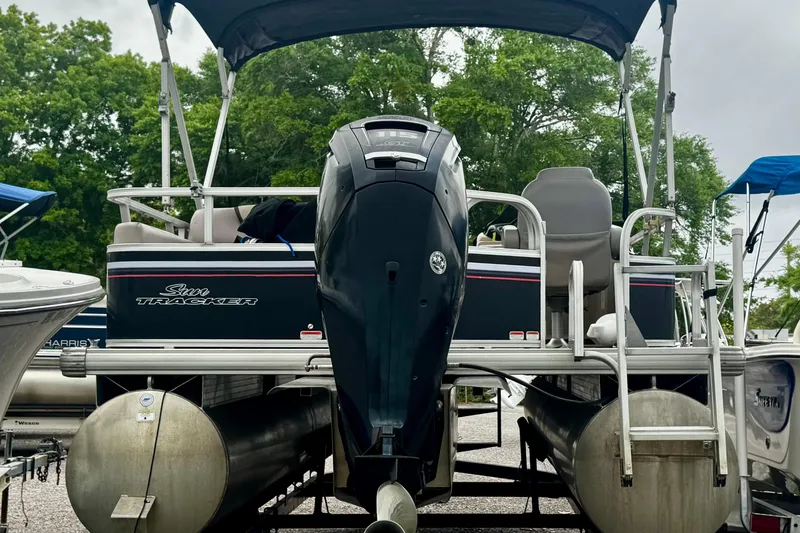 Slide: The Image of 2015 Sun Tracker Party Barge 22 DLX pontoon boat with canopy and motor, parked outdoors. - 3