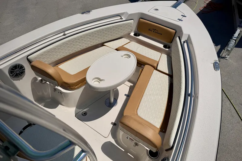 Slide: The Image of 2026 Sea Chaser 22 HFC boat interior with cushioned seating and round table. - 15