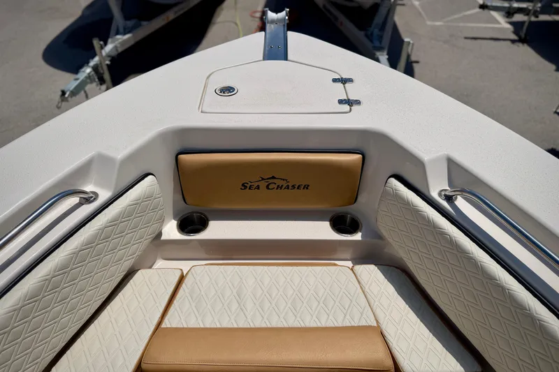 Slide: The Image of 2026 Sea Chaser 22 HFC boat interior with cushioned seating and logo. - 16