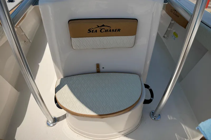 Slide: The Image of 2026 Sea Chaser 22 HFC boat seating area with logo and cushioned seat. - 20