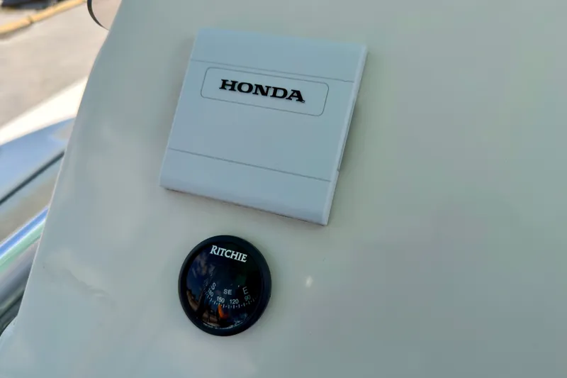 Slide: The Image of 2026 Sea Chaser 22 HFC boat dashboard with Honda panel and Ritchie compass. - 45