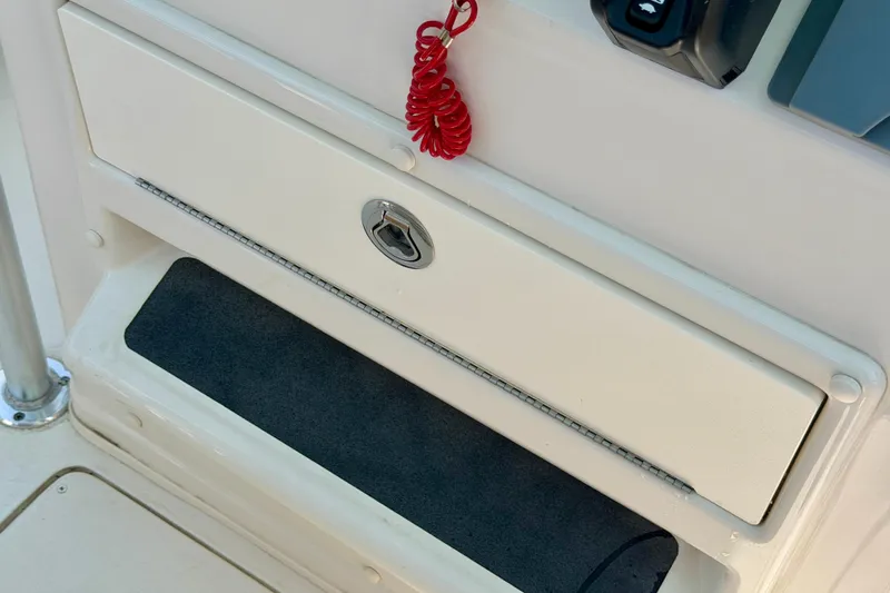 Slide: The Image of 2026 Sea Chaser 22 HFC boat storage compartment with lock and red safety cord. - 50