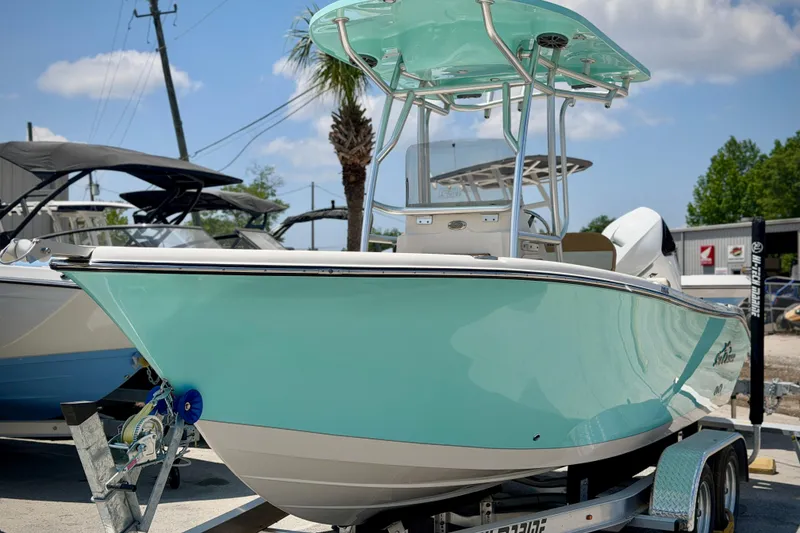 Slide: The Image of 2026 Sea Chaser 22 HFC boat on trailer, turquoise hull, sunny day. - 60