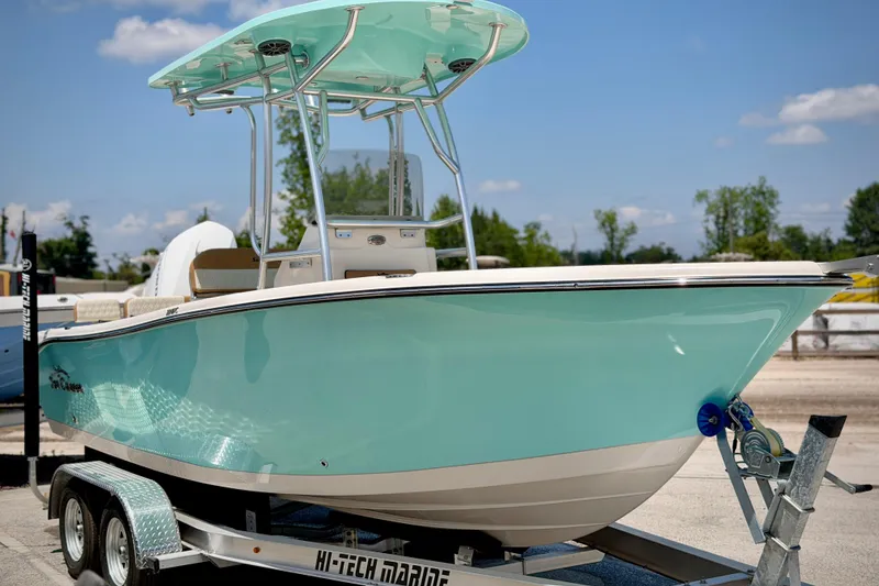 Slide: The Image of 2026 Sea Chaser 22 HFC boat on trailer, turquoise hull, sunny day. - 61