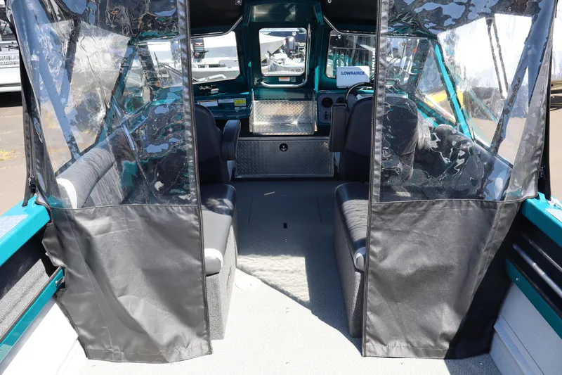 Slide: The Image of Interior view of a 2019 Northwest 208 SeaStar boat with seating and clear vinyl enclosures. - 5