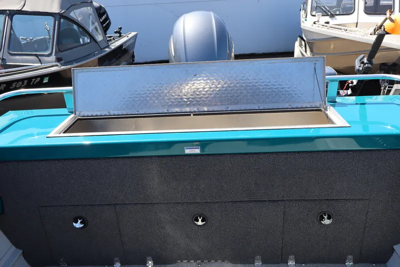 Slide: The Image of 2019 Northwest 208 SeaStar boat with open storage compartment, docked alongside other boats. - 6