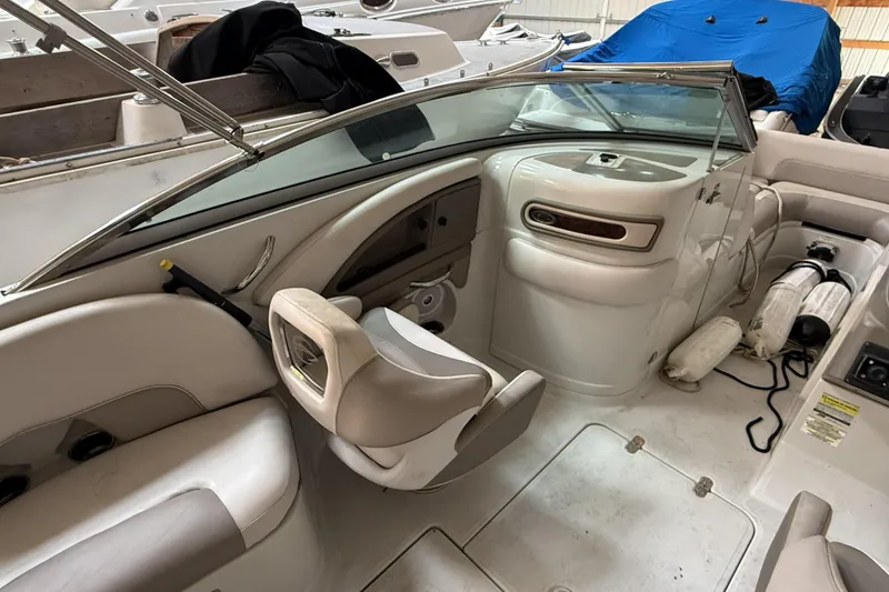 Slide: The Image of 2015 Crownline Eclipse E2 XS boat interior with seating and dashboard, stored indoors. - 14