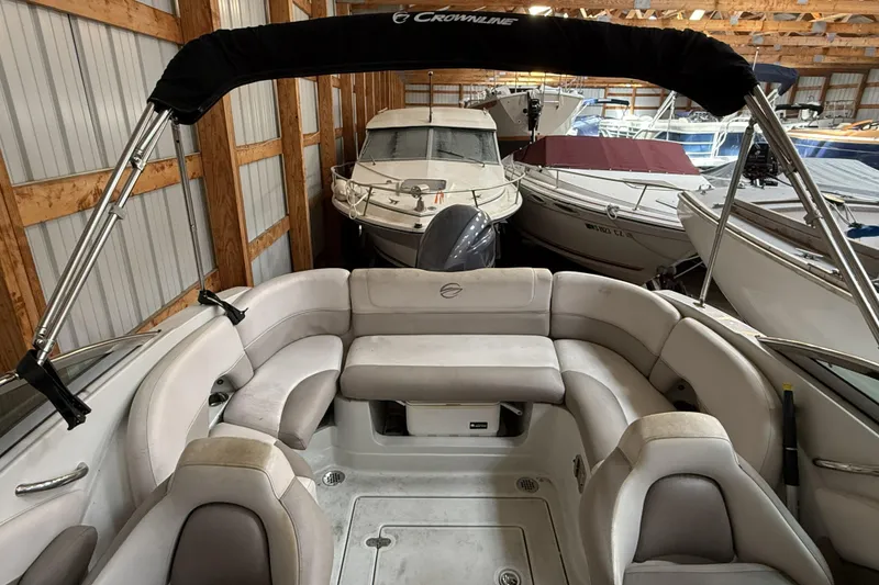 Slide: The Image of 2015 Crownline Eclipse E2 XS boat interior with seating, stored in a wooden boathouse. - 15